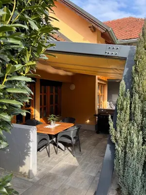 a patio with a wooden table and chairs at SISSI Apartment Banovci in Veržej