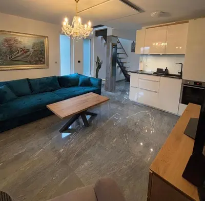 a living room with a blue couch and a table at SISSI Apartment Banovci in Veržej