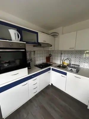 a kitchen with white cabinets and a stove top oven at Larisa apartma in Domžale