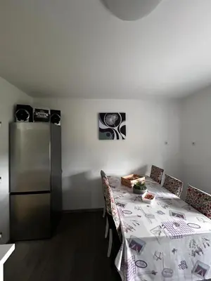 a dining room with a table and a refrigerator at Larisa apartma in Domžale