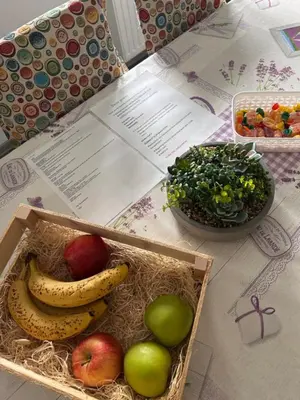 a box of fruit and a bowl of greens on a table at Larisa apartma in Domžale
