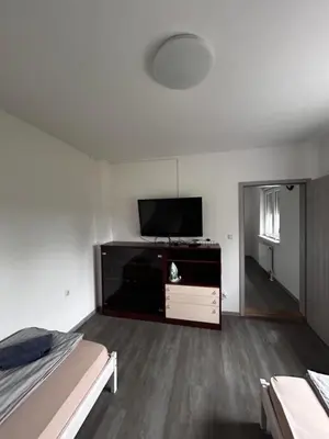 a living room with a flat screen tv and a bed at Larisa apartma in Domžale