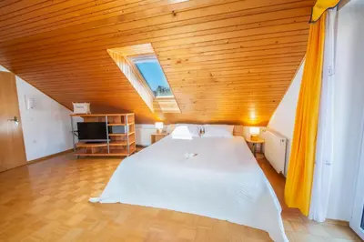 a bedroom with a white bed with a wooden ceiling at DREAMLAND BLED Apartments in Bled