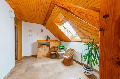 an attic room with wooden ceilings and a table and chairs at DREAMLAND BLED Apartments in Bled
