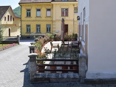 a building with benches in front of a building at Apartma Majerhold in Mozirje