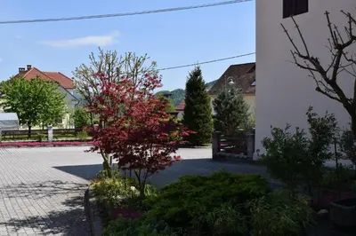 a tree with red leaves next to a building at Apartma Majerhold in Mozirje
