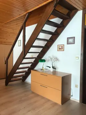 a room with a staircase and a dresser with a desk at Apartments Janjusevic in Bled