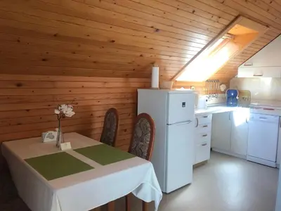 a kitchen with a table and a white refrigerator at Apartments Janjusevic in Bled