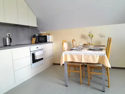 a kitchen with a table with chairs and a microwave at Apartments Janjusevic in Bled