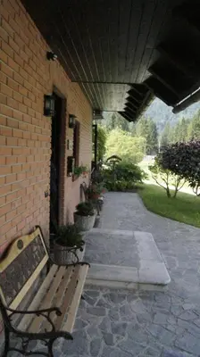 a bench sitting outside of a brick building at Apartments Janjusevic in Bled
