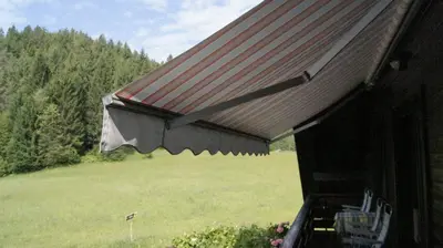 awning on the side of a house with a field at Apartments Janjusevic in Bled