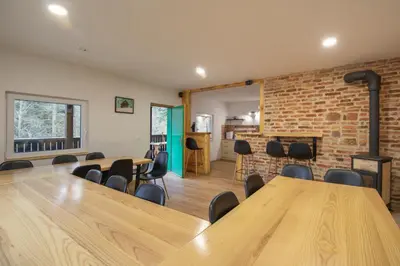 a room with a table and chairs and a brick wall at Chalet Fridrihštajn in Kočevje