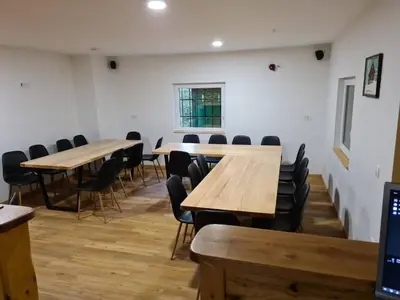 a room with wooden tables and chairs and a window at Chalet Fridrihštajn in Kočevje