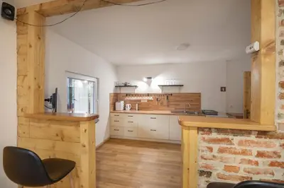 a kitchen with white walls and wooden floors at Chalet Fridrihštajn in Kočevje