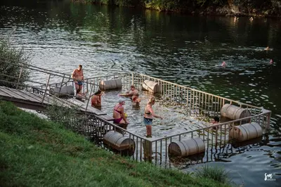 a group of people standing in the water on a dock at MAGNOLIA HOUSE by the RIVER BB in Primostek