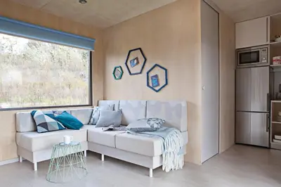 a living room with a white couch and a window at MAGNOLIA HOUSE by the RIVER BB in Primostek