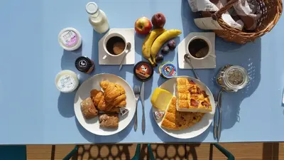 a blue table with two plates of breakfast food at MAGNOLIA HOUSE by the RIVER BB in Primostek