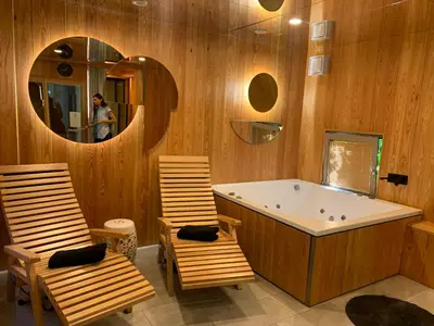 a bathroom with a tub and two chairs and a mirror at MAGNOLIA HOUSE by the RIVER BB in Primostek