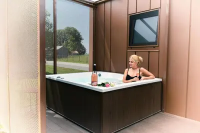 a woman sitting in a tub in a house at MAGNOLIA HOUSE by the RIVER BB in Primostek