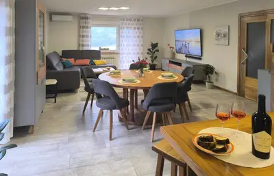 a dining room and living room with a table and chairs at Apartma Sunside in Branik