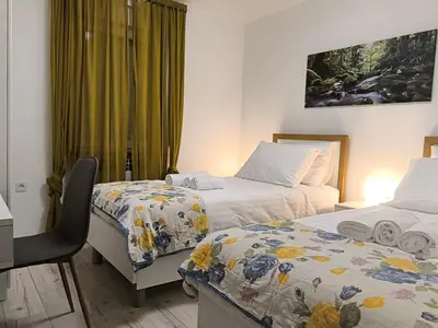 a hotel room with two beds and a desk at Apartma Sunside in Branik