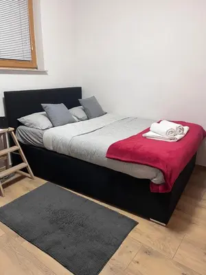 a bedroom with a bed with a red blanket at Urko Apartments Ljubljana in Ljubljana