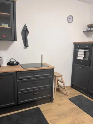 a kitchen with a black dresser and a counter at Urko Apartments Ljubljana in Ljubljana