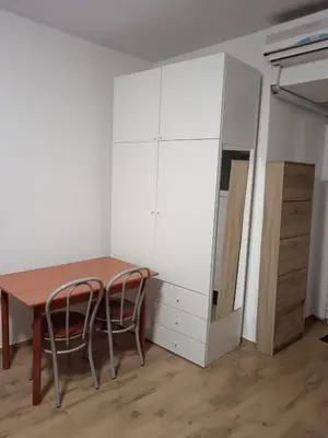 a room with a table and two chairs and a cabinet at Urko Apartments Ljubljana in Ljubljana