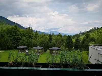 a view of a garden with tables and umbrellas at Guest house 902 Črnivec in Gornji Grad