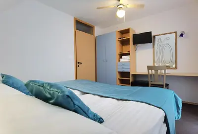 a bedroom with two beds and a desk at Guest house 902 Črnivec in Gornji Grad