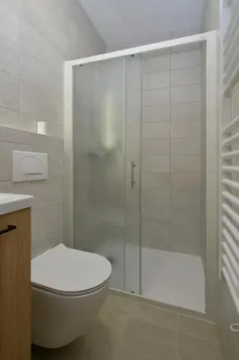 a bathroom with a toilet and a glass shower at Apartmaji Siliganum in Solkan