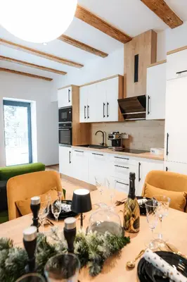 a kitchen with a table with wine glasses on it at Apartmaji Vouk - sodobni apartmaji v objemu narave - Lukanja - Rogla - Primerno za pare in družine - Sprostitev in aktivno preživljanje prostega časa in Oplotnica