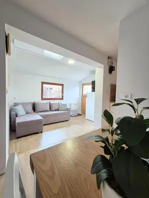 a living room with a couch and a potted plant at Terme Banovci - Pomurski raj, tickets included in Veržej
