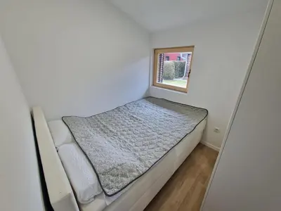 a small bed in a small room with a window at Terme Banovci - Pomurski raj, tickets included in Veržej