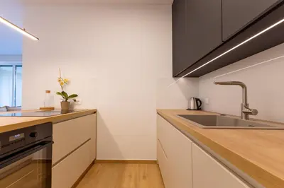 a kitchen with white cabinets and a sink at Apartment Bovec by Liza in Bovec