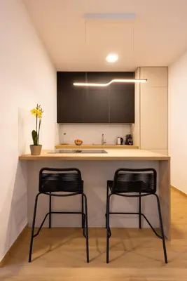two black chairs sitting at a kitchen counter at Apartment Bovec by Liza in Bovec