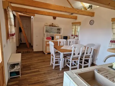 a kitchen and dining room with a table and chairs at Izba in Lendava