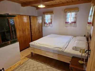 a bedroom with a bed in a room with windows at Izba in Lendava