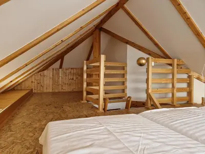 a attic room with a bed and a ladder at Izba in Lendava