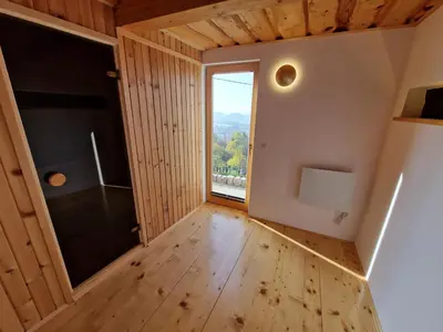 a room with a large window and a wooden floor at Izba in Lendava