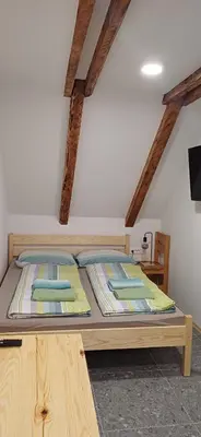 a large wooden bed in a room with wooden beams at HIŠA MARGIT, Studio APARTMA in Rateče