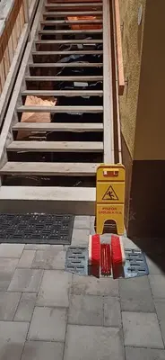 a yellow sign sitting on the floor next to a stairs at HIŠA MARGIT, Studio APARTMA in Rateče