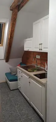 a kitchen with white cabinets and a sink and a bench at HIŠA MARGIT, Studio APARTMA in Rateče