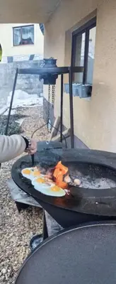 a person is cooking food on a grill at HIŠA MARGIT, Studio APARTMA in Rateče