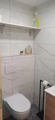 a white bathroom with a toilet and a sink at HIŠA MARGIT, Studio APARTMA in Rateče