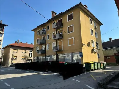 a building with a car parked in a parking lot at Lamant Apartment Cerkno in Cerkno