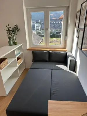 a living room with a couch and a window at Lamant Apartment Cerkno in Cerkno