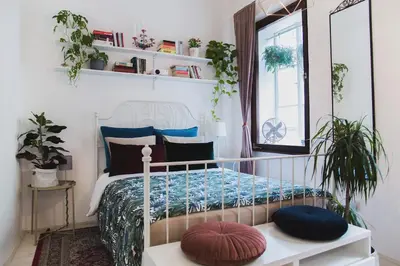a bedroom with a bed with a mirror and plants at Central Garden Studio in Ljubljana