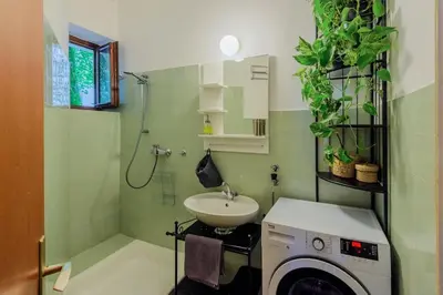 a bathroom with a washing machine and a sink at Central Garden Studio in Ljubljana