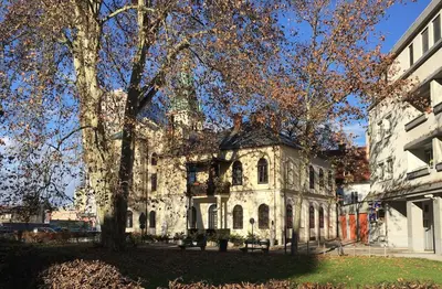 an old stone building with a tree in front of it at Central Garden Studio in Ljubljana
